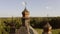 Close-up wooden domes of church and dense forest in the distance.