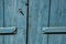 Close-up of wooden door and hinge painted blue, in the village of Lourmarin.