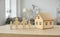 Close up of wooden figurines of family with children and model of small one-story house.