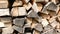 Close-up of wooden firewood stacked in rows. Fuel from logs billet. Natural combustible materials for heating. Selective focus