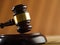 Close-up. Wooden gavel of the judge and in the background an open book on a dark beige background. Court and justice, Constitution