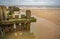 Close up of wooden groynes and sea defences on a sandy beach in North Norfolk