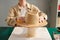 Close-up of wooden hat workpiece on table against craftswoman