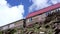 Close up of wooden huts on rock. Small one-story houses on mountain in sunny weather.