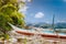 Close up of wooden local banca boat in front on the tropical beach covered with dry palm leaves, picturesque scenery at