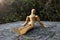 Close up of a wooden mannequin sitting on a tree trunk relaxing in quiet lonely forest