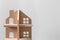 Close up of wooden minature house on bright background with place for text. Symbol of estate