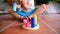 Close-up of a wooden montessori toy while a child play with him to develop his dexterity, defocused 2