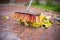 Close-up of a wooden mop with artificial bristles that sweeps fallen autumn leaves over a wet surface