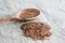 Close up of wooden spoon of flax seeds on a sackcloth. healthy foods