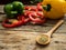 Close up wooden spoon with utensils herbs , colorful bell pepper at background