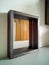 Close up of wooden stained mirror against the wall