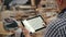 Close-up of woodworker using tablet at work looking at furniture design