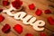 Close up of word love cutout with red rose on wood