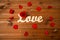 Close up of word love cutout with red rose on wood