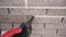 Close-up of a worker fills a joint between bricks with mortar from a sealant gun. The master evens out the seams between