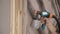 Close-up of worker hand using spray gun and painting wood in house