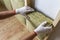 Close-up of worker hands in white gloves insulating rock wool insulation staff in wooden frame for future walls for cold barrier.