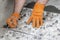 Close up of a worker`s hand leveling a ceramic tile. Process of laying tiles on floor.