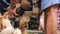 Close up of a worker`s hand peeling a dried coconut fruit, a farmer peeling a coconut with a sharp iron rod, the production proces