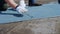 Close up of a worker s hands in gloves cutting a piece of roofing felt