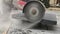 Close up. A worker`s hands using angle grinder. Close up of builder cuts paving slabs using angle grinder, making clouds of dust.