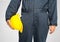 Close up Worker standing in blue coverall holding hardhat