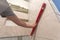 Close-up of worker tiler hand with lever installing on walls ceramic tiles. Tiles installation, tools and home improvement,