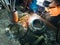 Close up worker welding steel with smoke and colourful of lights in industrial work shop