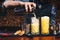 Close up of working bartender. Pouring citrus cocktail over ice, orange cocktail details