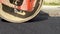 Close-up of a working ice rink lines hot asphalt. Pavement repair. The large working machine of the roller makes new asphalt