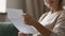 Close up wrinkled female hands holding paper document.