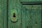 Close-up of wrought iron keyhole in an old wooden worn door