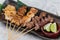 Close-up Yakitori Japanese-Style Grilled Chicken Skewers with chicken and internal organ served with sliced lime.