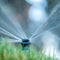 Close up of yard sprinkler with blurred background