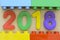 Close up of year 2018 in colorful plastic numbers surrounded by plastic toy blocks