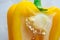 Close-up of yellow bell pepper cut. Matured shiny pulp with seeds