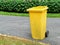 Close up of yellow bins in public park beside the walk way