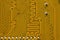 Close-up of a yellow circuit board. The reverse side of the motherboard of a personal computer. Background for