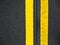 Close-up yellow dividing lines on the road with copy space. Yellow double solid line. Road markings on asphalt. Gray asphalt