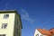 Close up of the yellow house. Yellow house with red tiled roof. Clear blue sky background with some autumn foliage on