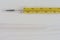 Close-up of yellow mercury medical thermometer on white wooden background horizontal