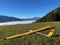 Close up of yellow model airplane laying in grass, Triesenberg, Liechtenstein, foggy Rhine valley in the background.