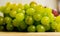 Close up of a yellow muscat colored grape on a wooden board