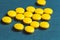 close up of yellow pills on a blue background