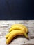 Close-up of yellow ripe bananas on an abstract wooden surface.