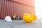 Close up yellow safety helmet on floor with man and woman foreman  engineering wearing protection mask sitting containers shipping