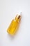 Close-up yellow serum essence in glass bottle. Isolated skincare oil