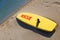 Close up yellow surfing board on sand sea beach
