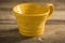 Close Up of Yellow Teacup on a Wooden Surface